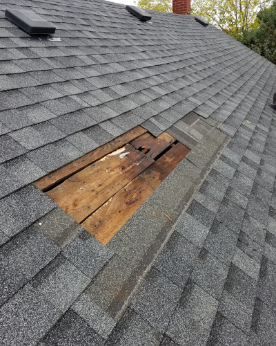 An image of roof of a house with damaged and torn singles.