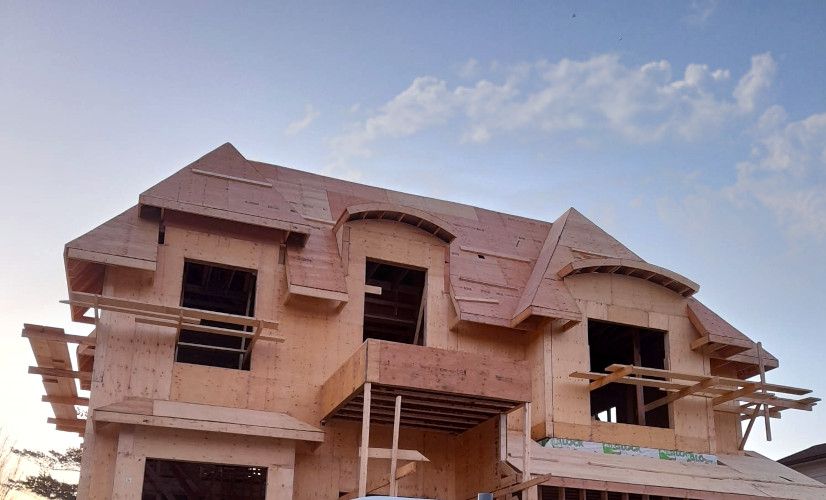 An image of a house on construction without windows, panels and roof shingles.